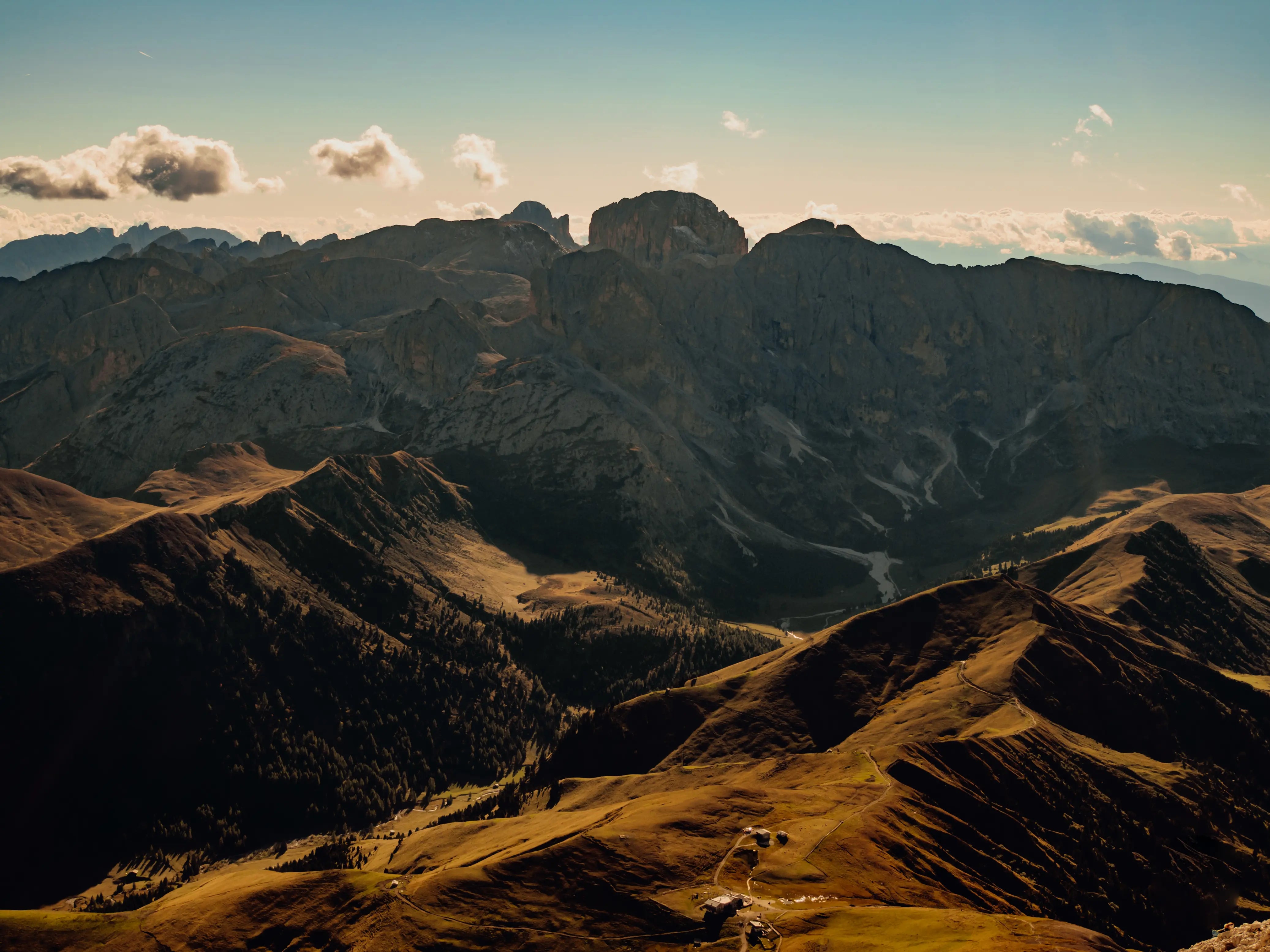 Scenic views of brown almost goldike fields and mountains with a blue sky and clouds in the sky