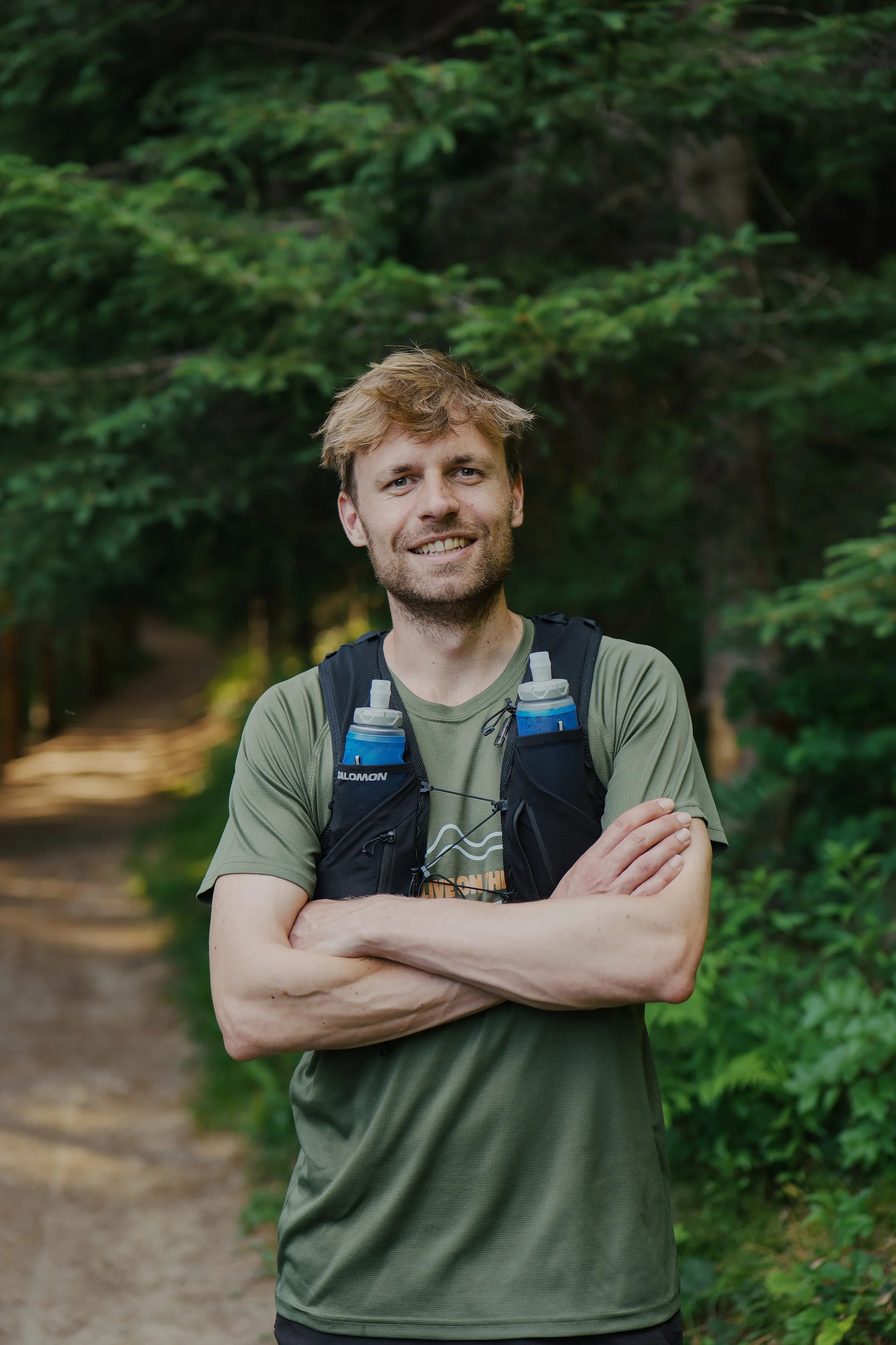Co-founder of drippr, Stijn, standing in. a forest with his running outift on.